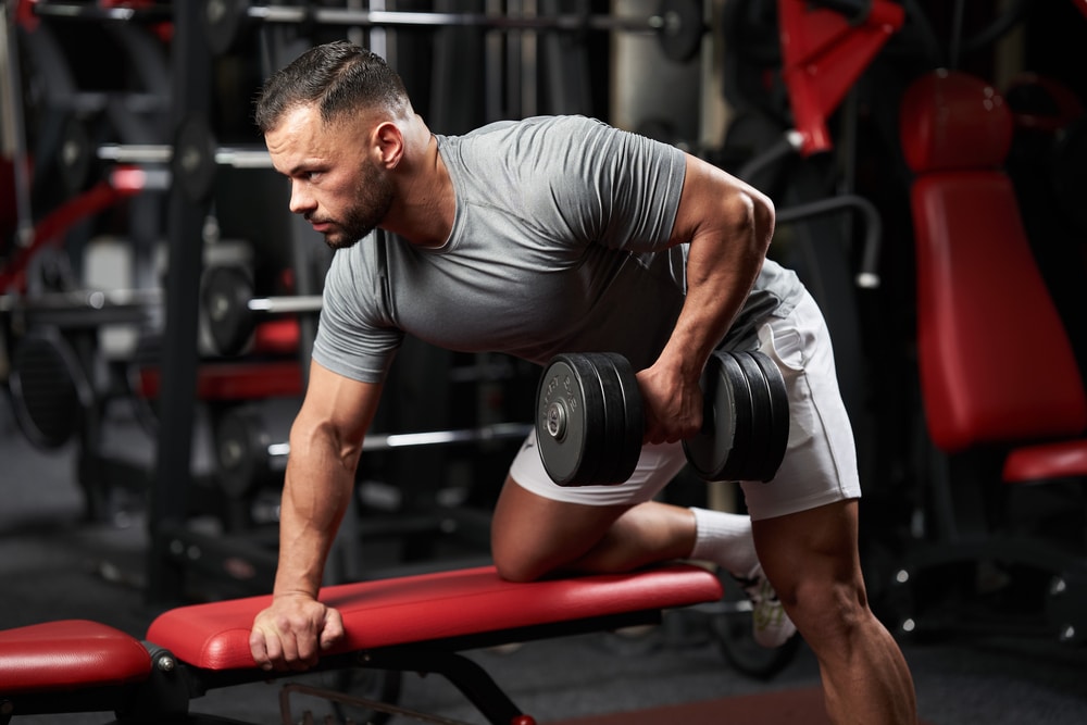 Bodybuilder Doing Dumbbell Row For Back Workout On A Bench