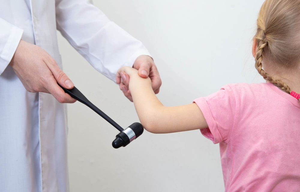 Checking The Child's Elbow Reflex With A Neurological Hammer Close up