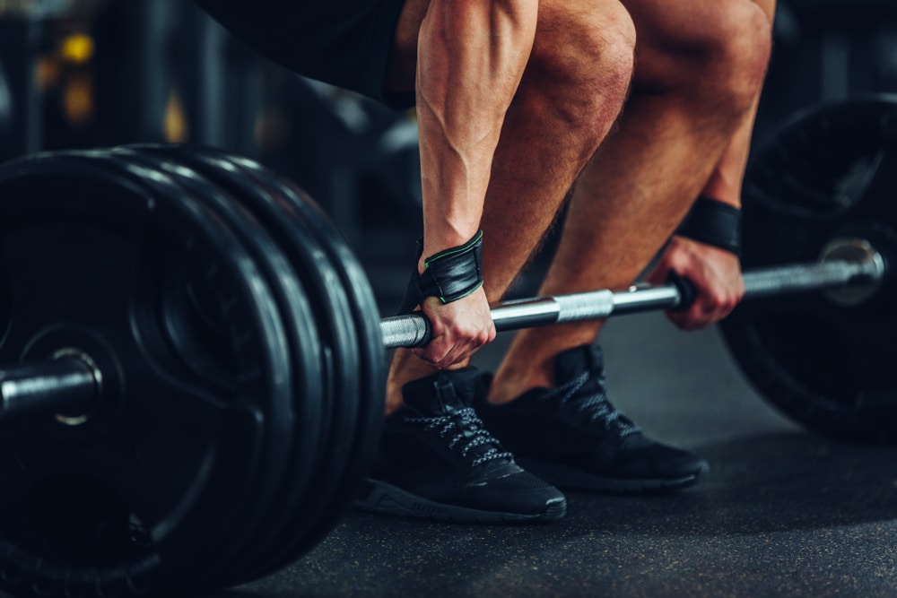 Cropped Shot Of A Man Lifting A Bar With Plates