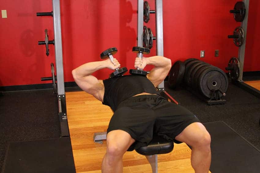 a man doing laying tricep exercise