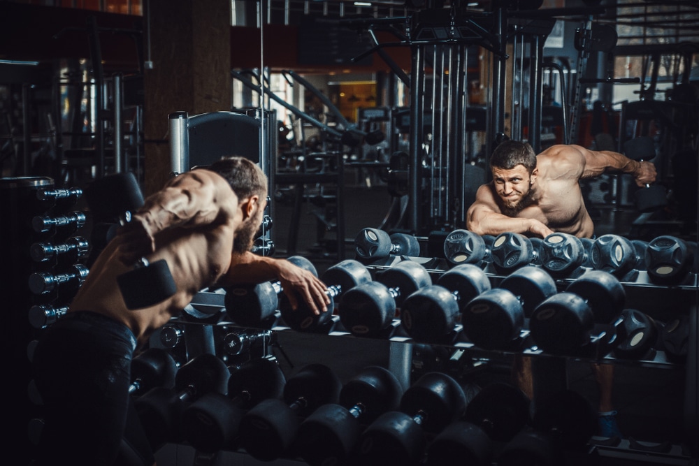 Good Looking Young Man Bodybuilder Doing Triceps Kickback Lifting Dumbbells