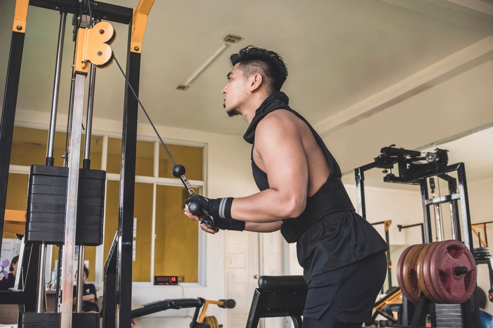 A Serious And Tanned Asian Guy Doing Cable Tricep Push