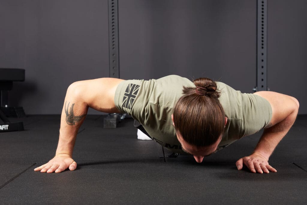 man doing pushups in a gym