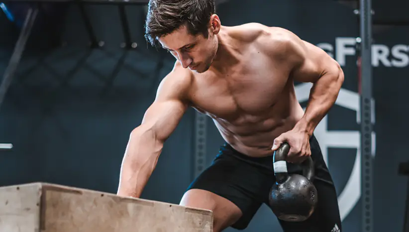 a man doing kettleball exercise in a gym