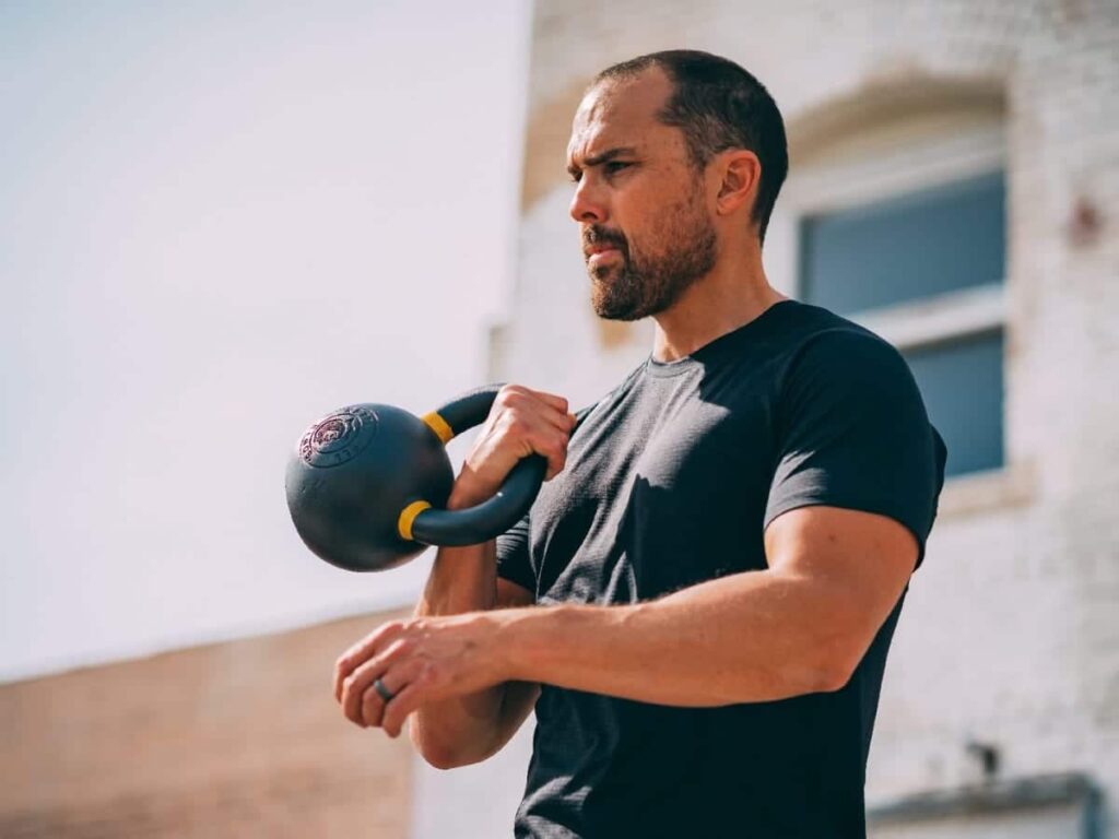 a man is doing kettle ball one arm exercise