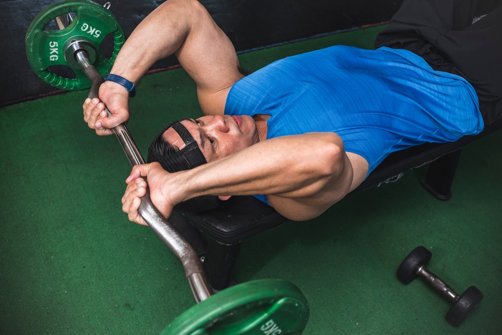 An Athletic Male Does A Set Of Lying Tricep Extensions