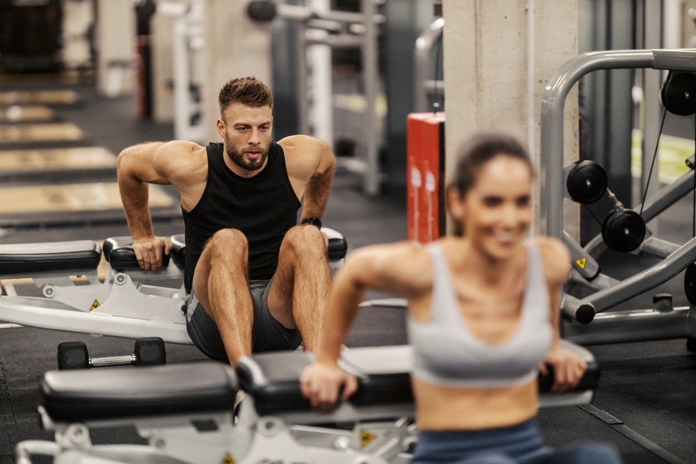 A Muscular Sportsman Is Doing Dips On A Bench with hands