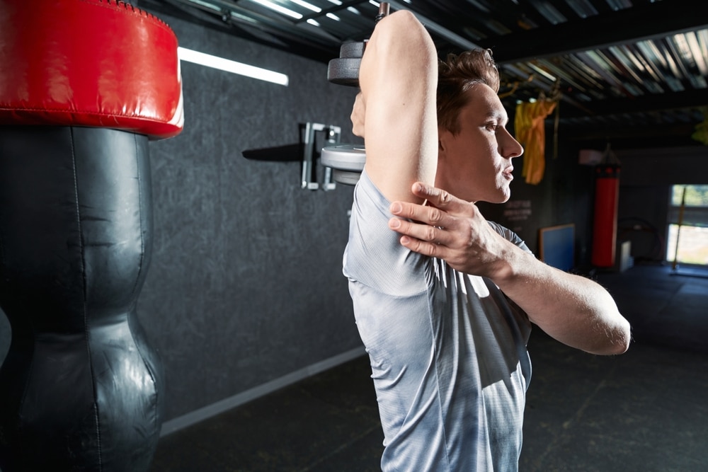 Athletic Man Doing Strength Training Exercise At Gym